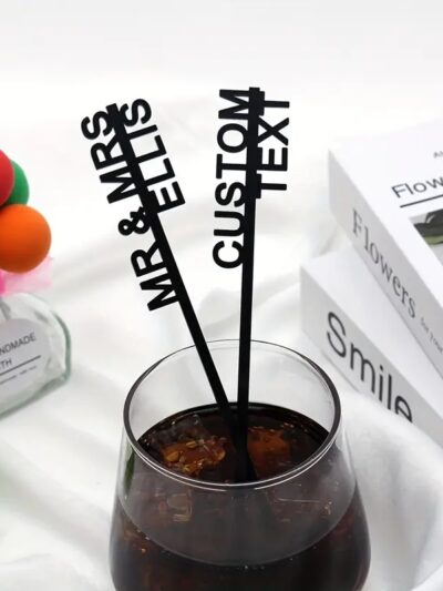 Custom text drink stirrers with MR & MRS initials in black design placed in a cocktail glass