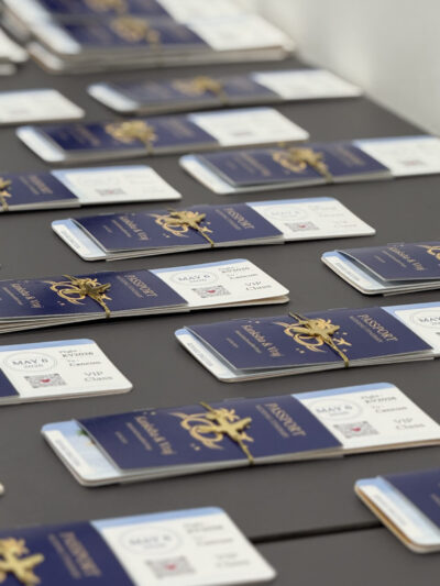 Luxury wedding passport invitation cards arranged on a table with navy blue covers, gold emblem detailing, and personalized boarding pass inserts for a destination wedding.