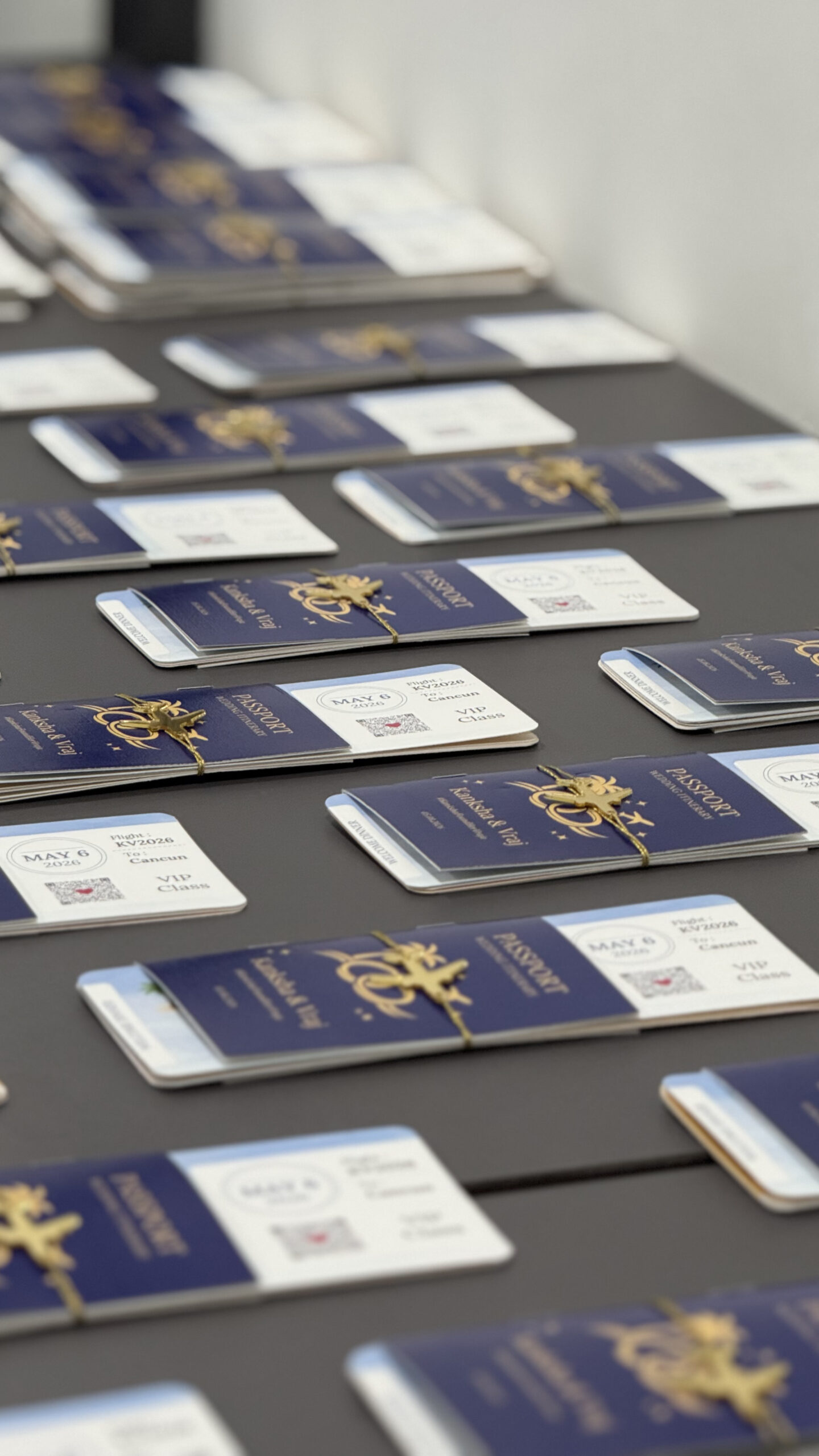 Luxury wedding passport invitation cards arranged on a table with navy blue covers, gold emblem detailing, and personalized boarding pass inserts for a destination wedding.