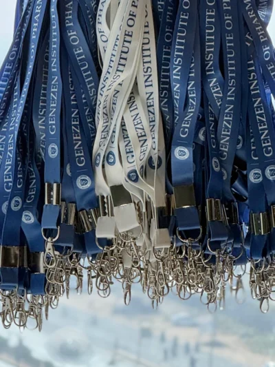 Blue customized logo lanyards with metal clips hanging in bulk for corporate distribution.
