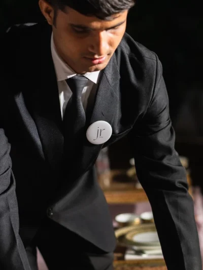 Corporate staff member wearing a custom logo pin badge on a formal suit for branding and professional event presentation.