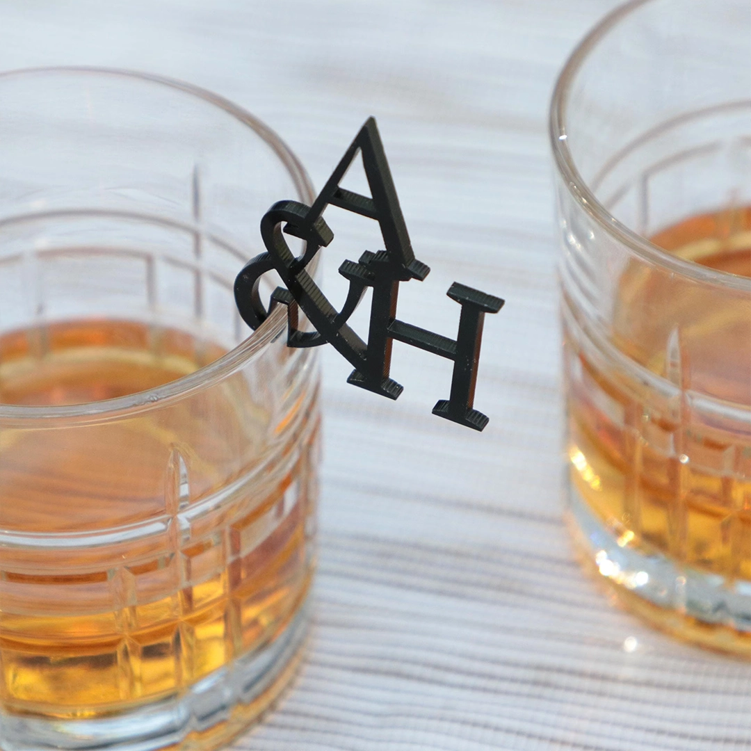 Custom A&H drink stirrer clipped on glass rim for cocktails and whiskey glasses