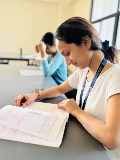 Student wearing a customized logo ID card lanyard while studying in a classroom environment.
